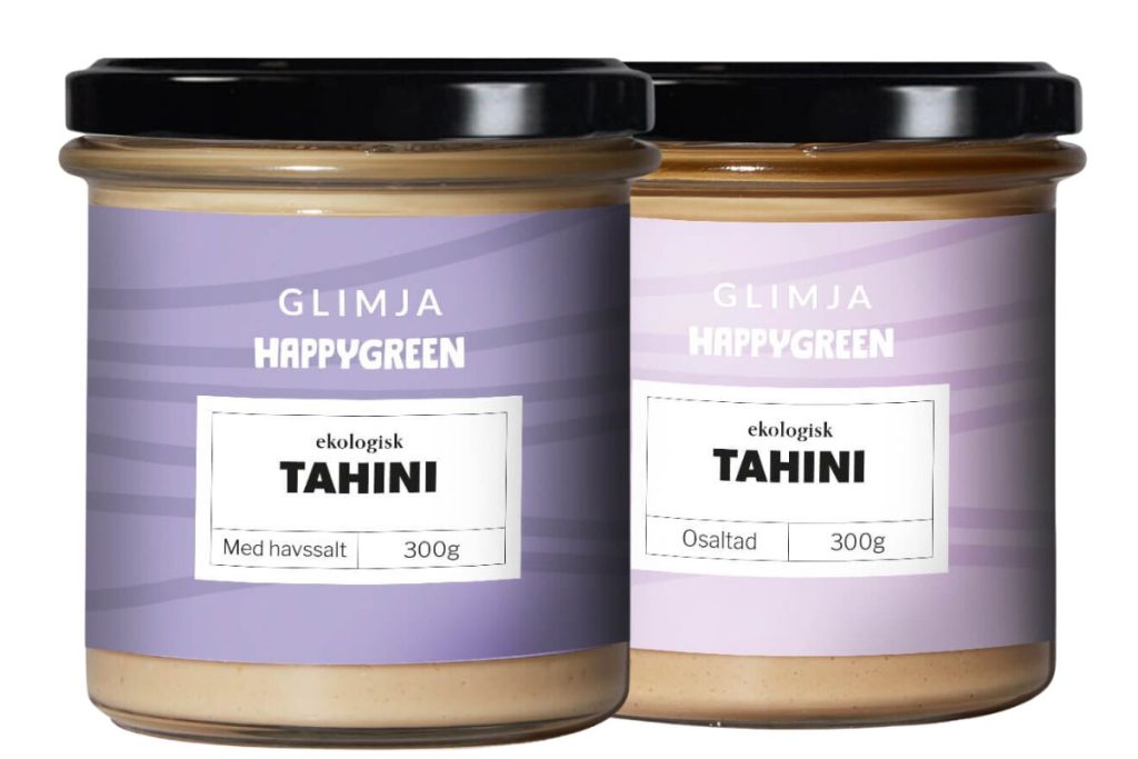To glas Glimja Happy Green Tahini, en med havsalt og en usaltet.