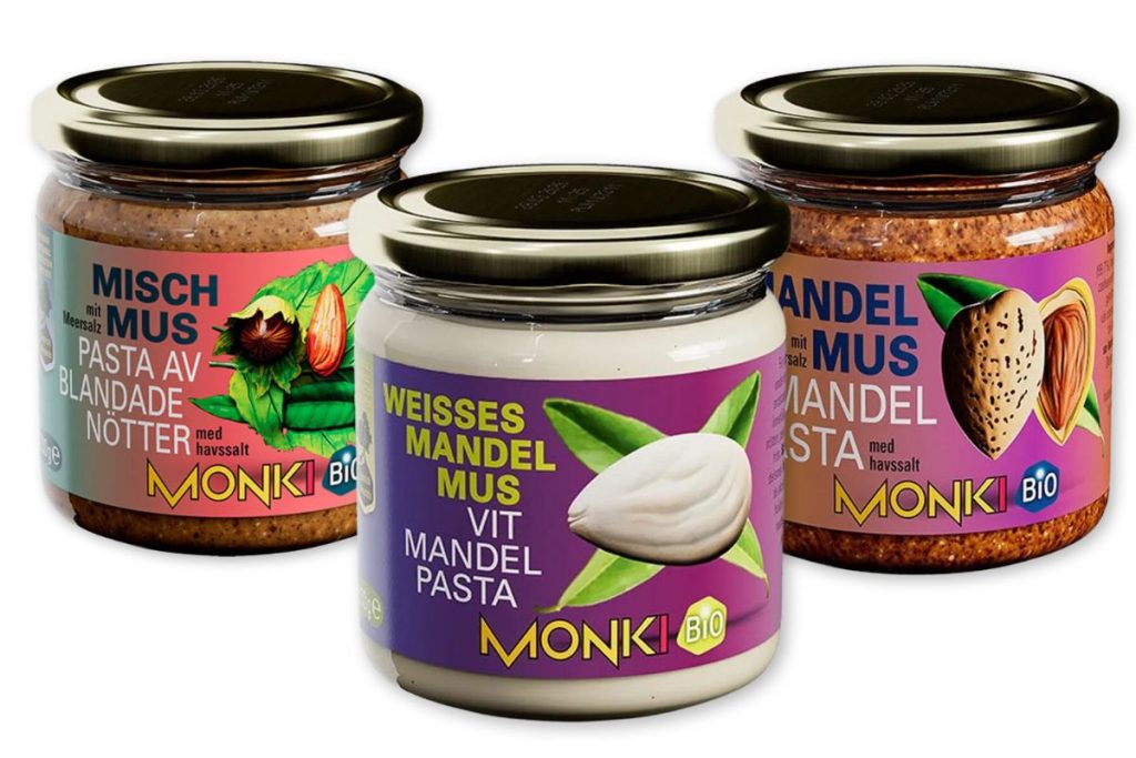 Tre glas Monki mandelsmør i forskellige varianter: blandede nødder med havsalt, hvid mandelpasta, og brun mandelpasta med havsalt.