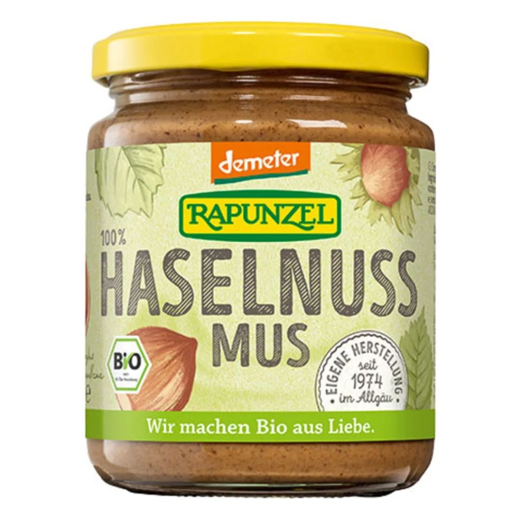 Glas med Rapunzel økologisk hasselnøddecreme med gul låg og grøn etiket.
