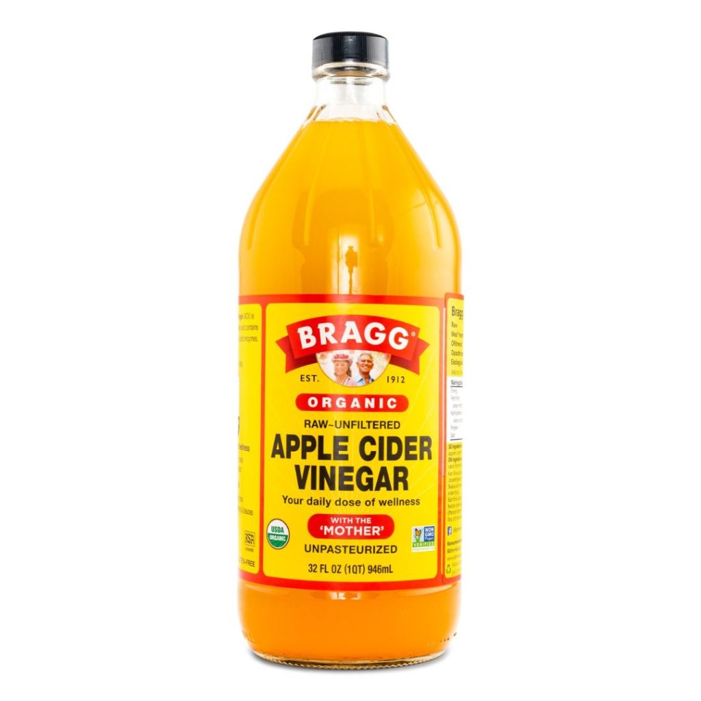 Bragg Organic Apple Cider Vinegar i en stor klar flaske med gul etiket.