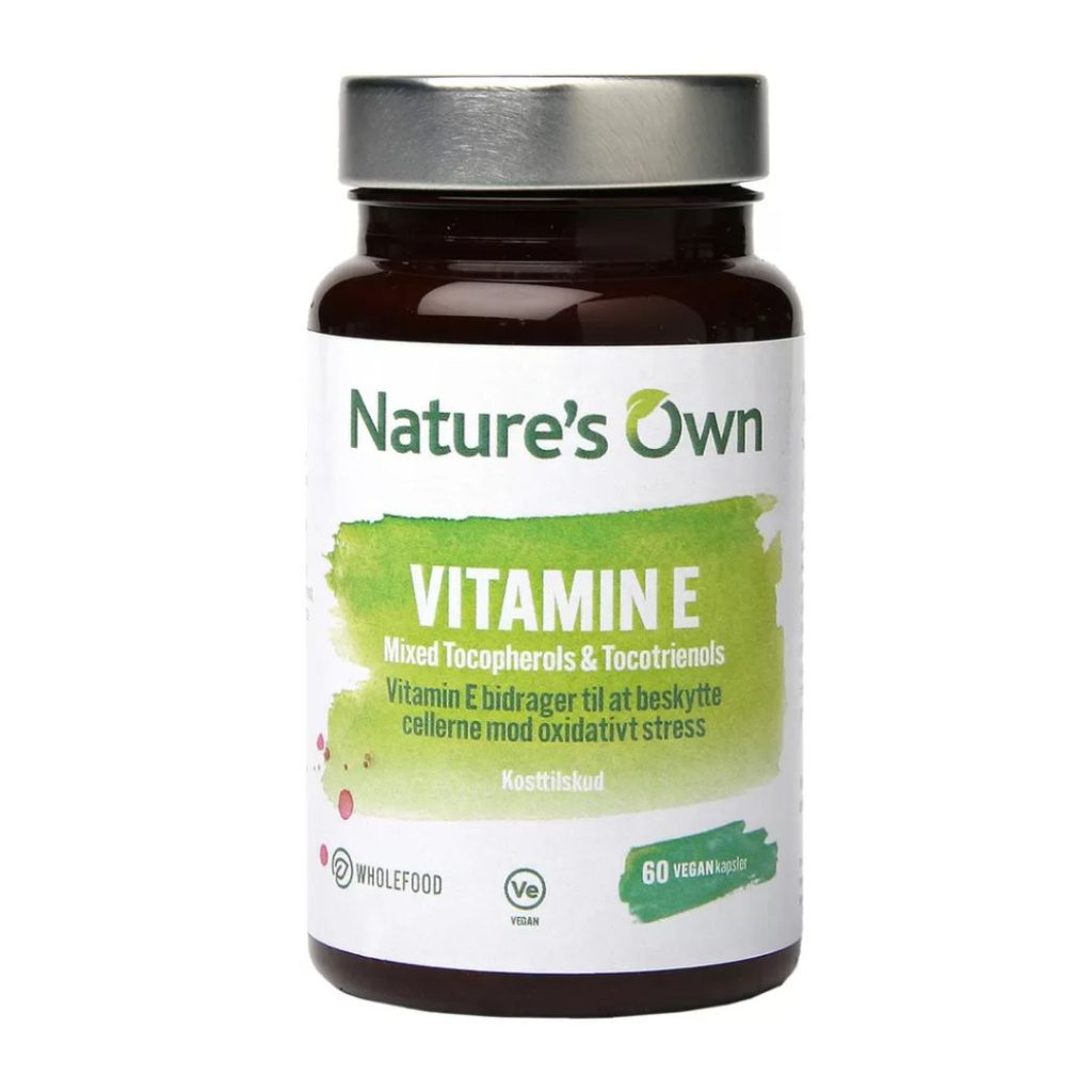 Brun glasflaske med hvid og grøn etiket, der viser "Nature’s Own Vitamin E – Mixed Tocopherols & Tocotrienols".